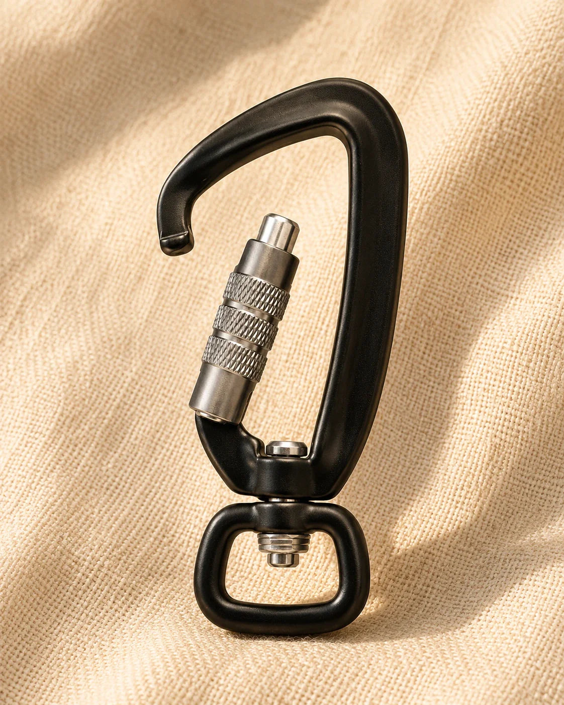 The Latch in matte black with brushed aluminum screw-lock gate on warm cream linen background